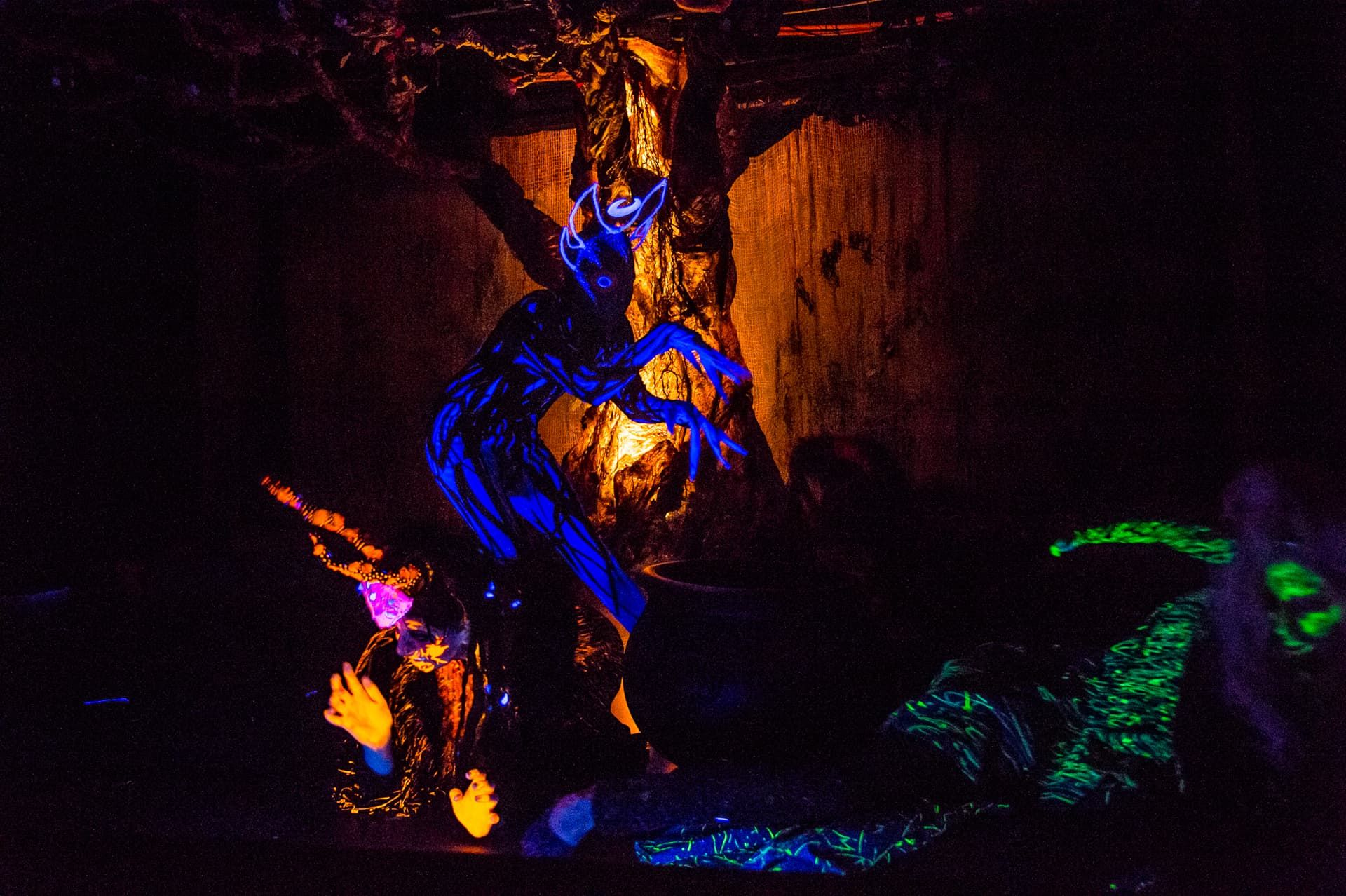 Blacklight-painted creatures haunt the stage in Macbeth